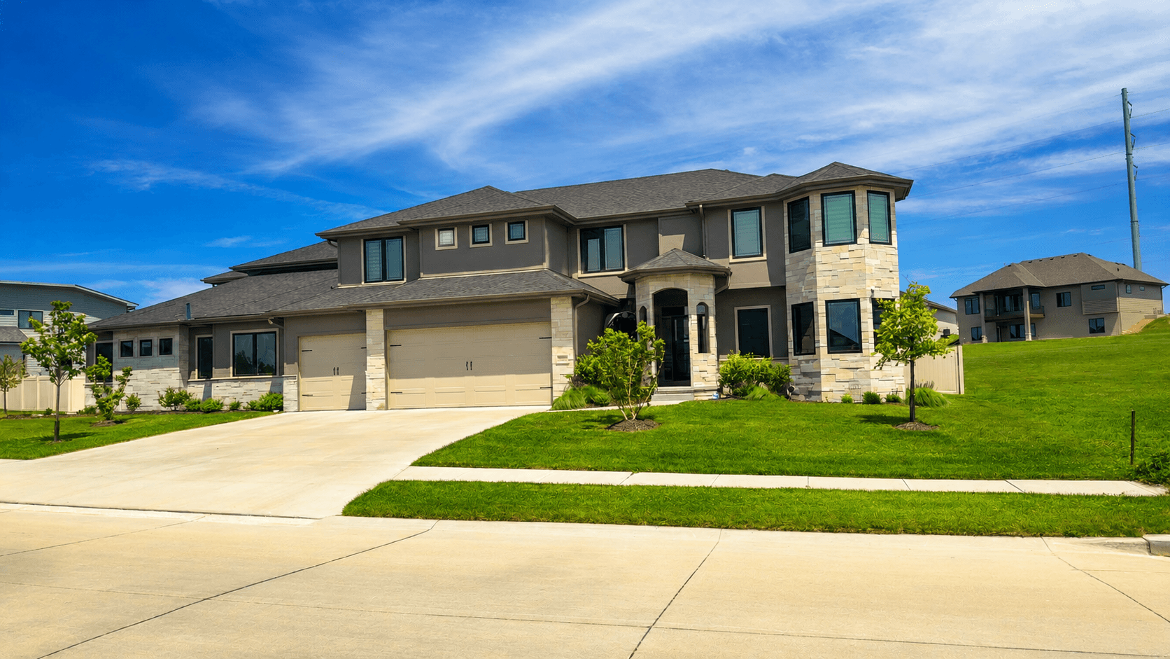 Modern 4,500 sqft Omaha estate home with freshly cleaned dark-siding windows under a blue sky